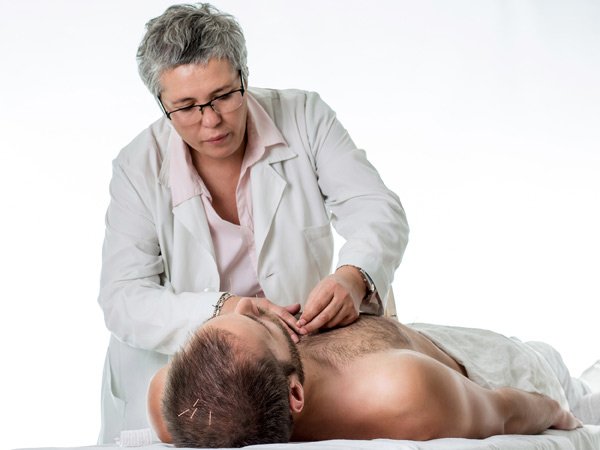 Pilar Jiménez Pradera aplicando acupuntura en el cuello de un paciente