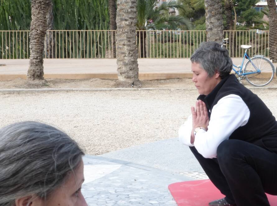 Pilar Jiménez Pradera meditando con manos en posición de oración en un parque, terapeuta de bienestar
